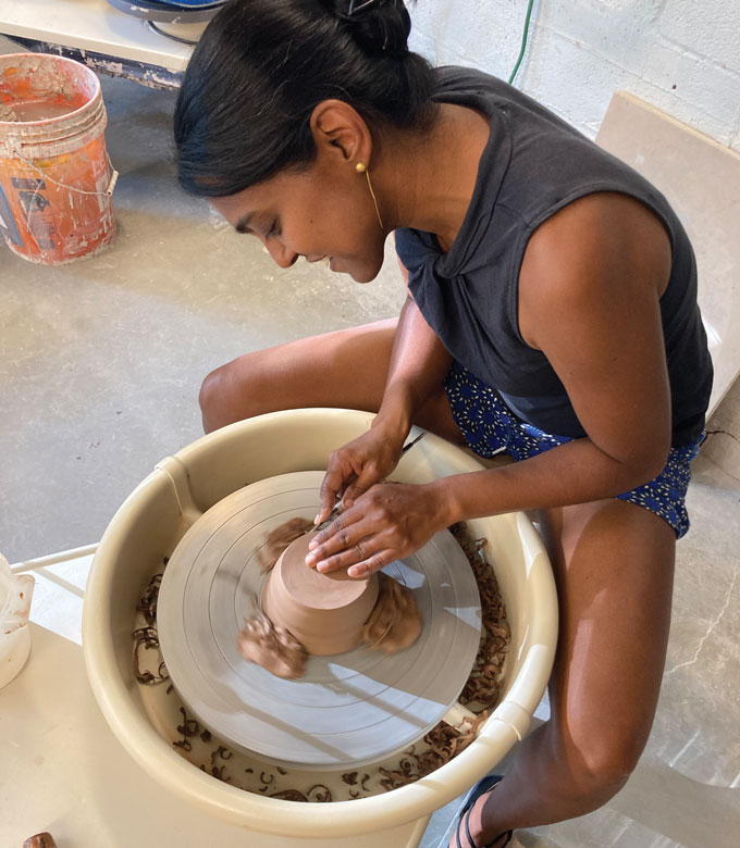 Sujata forming a pot on a pottery wheel